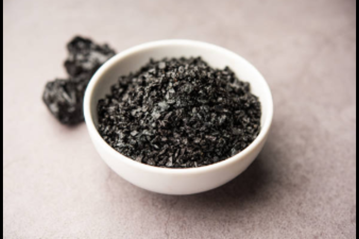 Close-up image of a white bowl filled with shiny black sesame seeds on a light surface, with scattered seed clusters nearby—highlighting the texture and culinary appeal of this nutrient-rich ingredient.